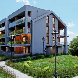 Nowoczesny budynek wielorodzinny z garażem podziemnym w Siedlcach, elewacja frontowa z balkonami wykonczonymi szklem