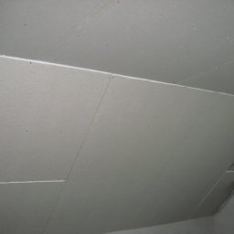 Firma Remontowo-Budowlana Paweł Kuchta - Płyty gipsowo-kartonowe zamontowane na poddaszu, widoczne łączenia płyt i elementy instalacji wentylacyjnej.