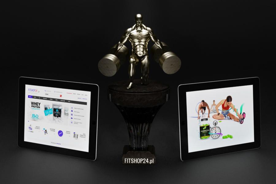 Dwa tablety wyświetlają stronę sklepu internetowego z odżywkami i ćwiczeniami, pomiędzy nimi statuetka kulturysty na postumencie, całość na czarnym tle.
