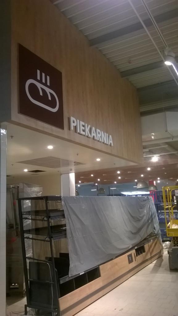 Wnętrze sklepu Kaufland w Bielsku Białej w trakcie remontu: widoczny napis 'Piekarnia' nad wejściem, regały zabezpieczone folią, sufit z oświetleniem.
