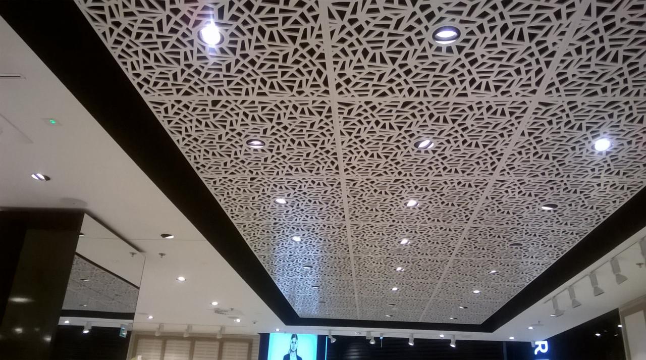 Dekoracyjny sufit podwieszany z ażurowym wzorem geometrycznym i oświetleniem punktowym w salonie RESERVED CH MOKOTÓW.