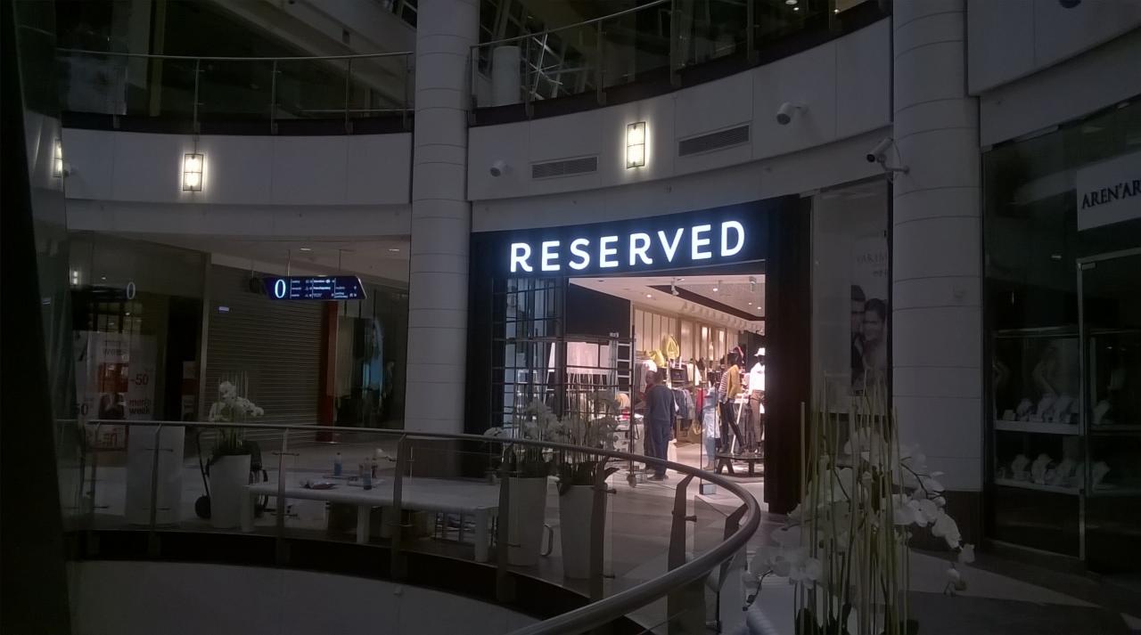 Wejście do sklepu Reserved w centrum handlowym, widok z góry, widoczne logo i klienci wewnątrz.