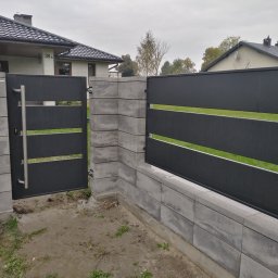 Dod-met - Nowoczesna, pozioma, metalowa brama wjazdowa w kolorze antracytowym, z uchwytem ze stali nierdzewnej, zamontowana na murku z szarej kostki betonowej, z widokiem na dom z ciemną dachówką