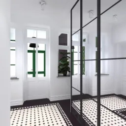 Korytarz w stylu retro z czarno-białą podłogą w geometryczne wzory, białe ściany i drzwi z zielonymi ramami, przeszklenie z czarnymi szprosami, roślina doniczkowa na parapecie.