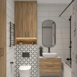REMONTY I WYKOŃCZENIA DOMÓW I MIESZKAŃ Arkadiusz Ruszkowski - Nowoczesna łazienka z drewnianymi szafkami, białą armaturą i geometrycznymi płytkami podłogowymi oraz ściennymi. Minimalistyczny design z akcentami roślinnymi.
