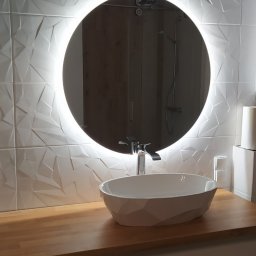 REMONTY I WYKOŃCZENIA DOMÓW I MIESZKAŃ Arkadiusz Ruszkowski - Nowoczesna łazienka z umywalką nablatową, okrągłym lustrem z podświetleniem LED i trójwymiarowymi białymi płytkami na ścianie. Widoczna pralka LG.