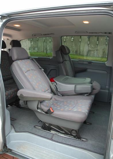 Wnętrze szarego busa z regulowanymi fotelami i podłokietnikami, przygotowanego do komfortowego przewozu osób w Oleśnicy.