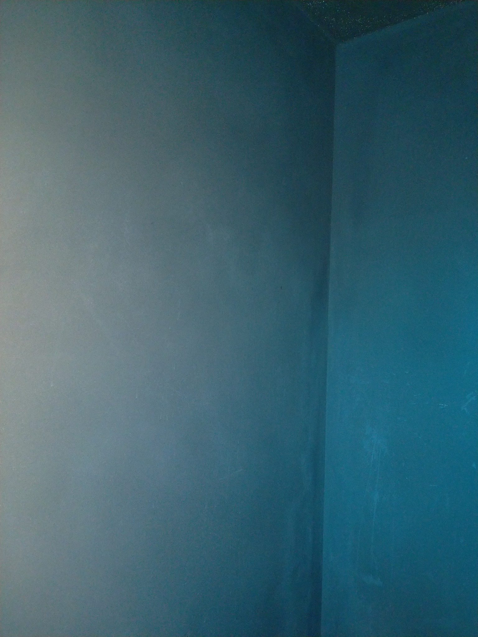 Pomieszczenie po malowaniu ścian na kolor morski, widoczny róg pokoju i ślady po wałku