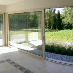 Nowoczesne, przesuwne okna tarasowe z widokiem na ogród z kwitnącą lawendą, jasna podłoga z dekoracyjnym wzorem.