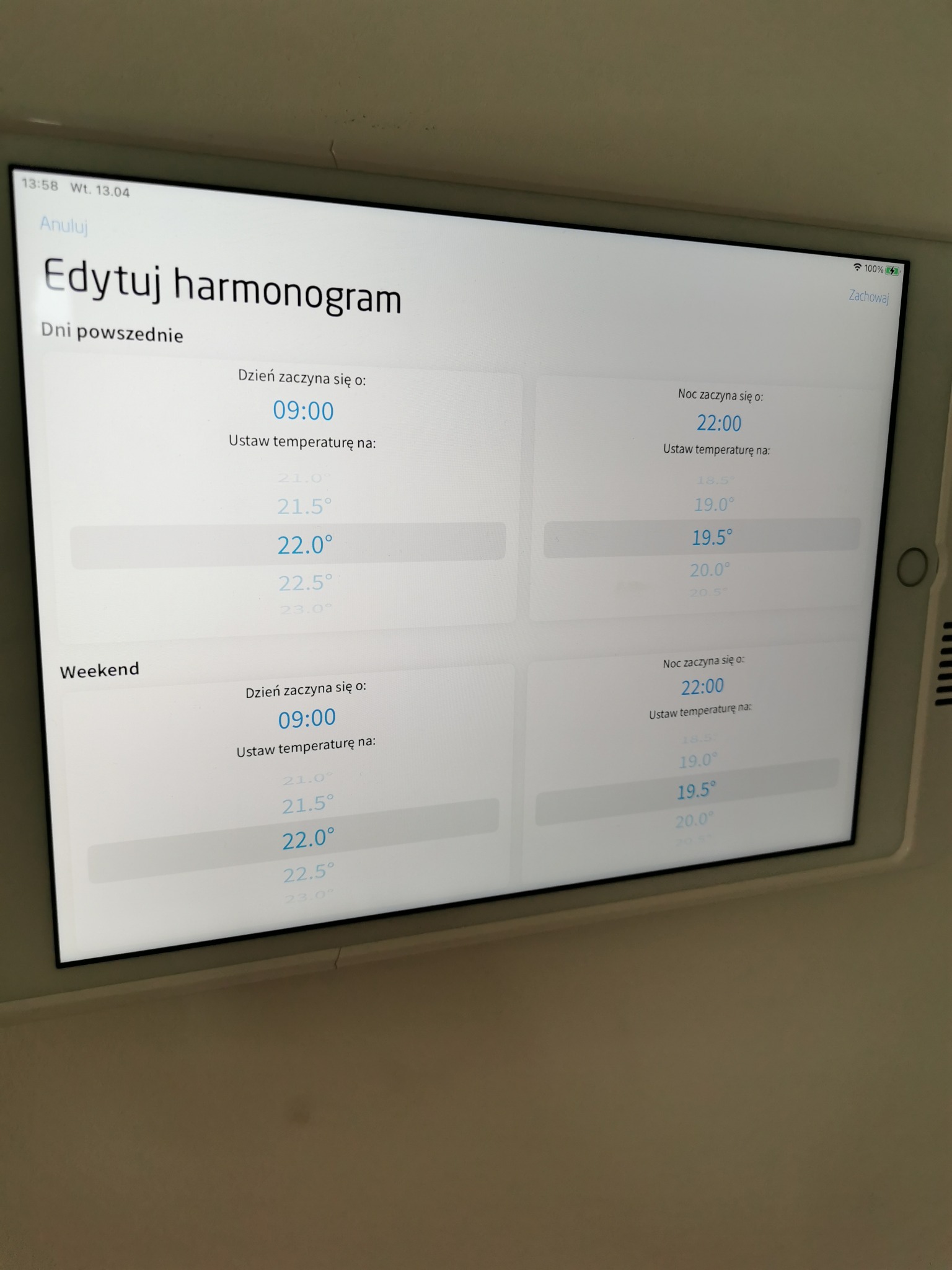 Tablet wyświetlający ekran edycji harmonogramu temperatury w domu, z ustawieniami dla dni powszednich i weekendu, dzień zaczyna się o 9:00, noc o 22:00, z możliwością ustawienia temperatury.