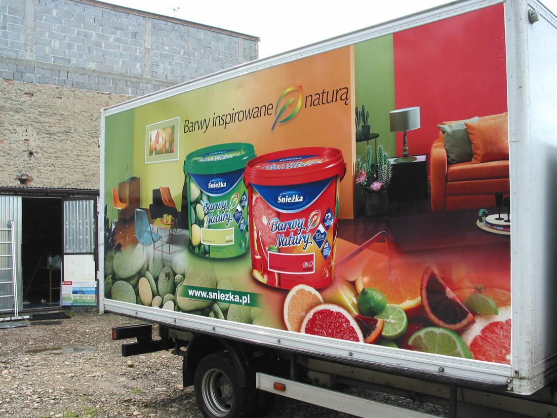 Oklejony samochód dostawczy z reklamą farb Śnieżka Barwy Natury, przedstawiającą aranżacje wnętrz i owoce.