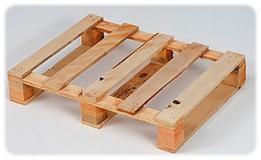 Jasna, drewniana paleta euro z widocznymi deskami i wspornikami, sfotografowana pod kątem na białym tle. Widoczne ślady po gwoździach.