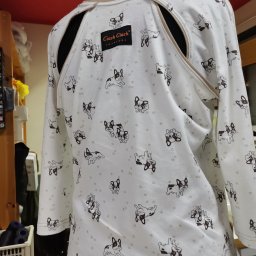 Ciach ciach - Biała bluzka z długim rękawem, z rozcięciami na ramionach i wzorem w buldogi francuskie, prezentowana na manekinie, z widoczną metką producenta.