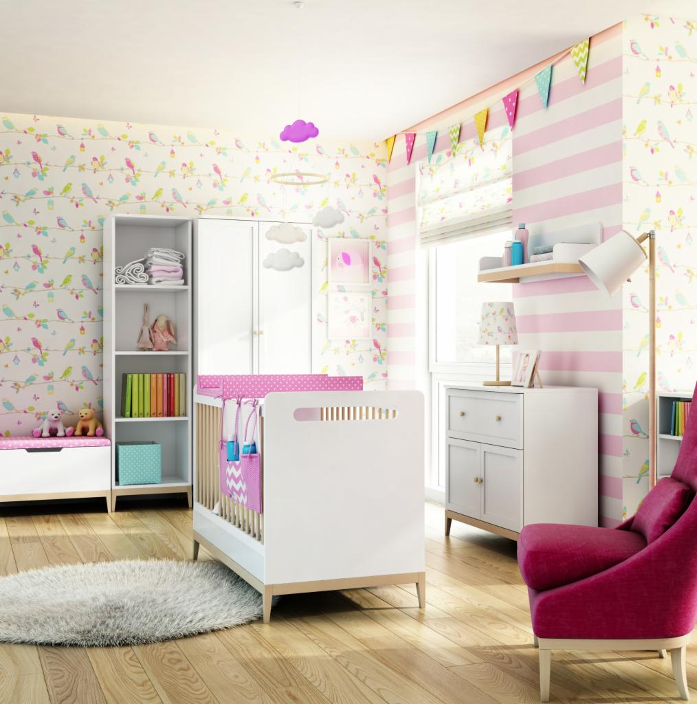 Jasny pokój dziecięcy z białym łóżeczkiem z różowym ochraniaczem w kropki, białymi meblami, wzorzystą tapetą w ptaszki i różowo-białymi pasami, miękkim dywanem i fotelem w kolorze fuksji.