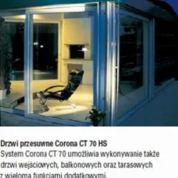 Przeszklona weranda z systemem przesuwnych drzwi SCHUCO Corona CT 70 HS, widok z zewnątrz, wewnątrz widoczne krzesło wypoczynkowe i oświetlenie.