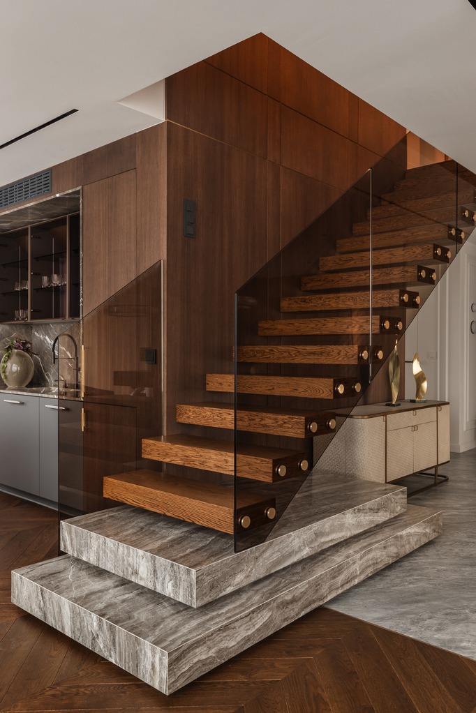 Schody półkowe wykończone olejowoskiem, szklana balustrada