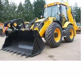 Żółta koparko-ładowarka z czarną łyżką, widok z boku na placu budowy, w tle zieleń.