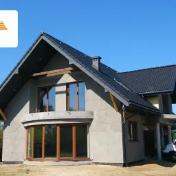 Dom jednorodzinny w trakcie ocieplania elewacji, z widocznymi oknami i firmowym samochodem dostawczym z reklamą pianki PUR. Logo Cels i Icynene.