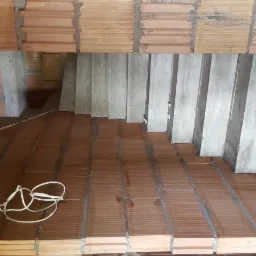 Wykonywanie podłogi z terakoty na legarach betonowych, widok z góry, przewód elektryczny na podłodze.