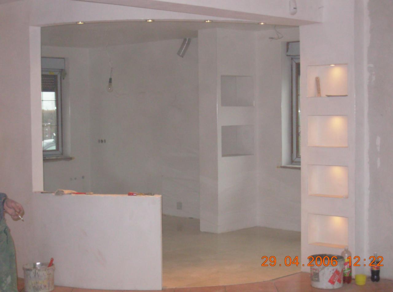 Prace wykończeniowe w trakcie realizacji w Zawoi: widok na pomieszczenie z podwieszanym sufitem z oświetleniem punktowym, ścianami przygotowanymi do malowania i wnękami dekoracyjnymi, widoczny...