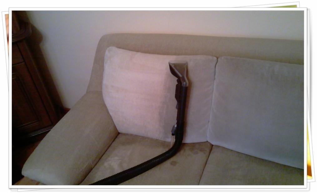 Dysza odkurzacza piorącego na beżowej kanapie podczas czyszczenia tapicerki, widoczny fragment mebla w tle.