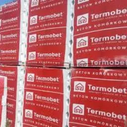 Paleta czerwonych opakowań bloczków z betonu komórkowego Termobet, składowana w Wadowicach, widoczna etykieta producenta.