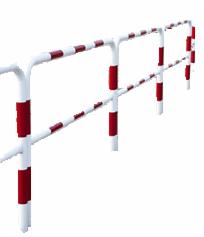 Białe barierki chodnikowe z czerwonymi, odblaskowymi pasami, ustawione wzdłuż chodnika, widok z perspektywy.