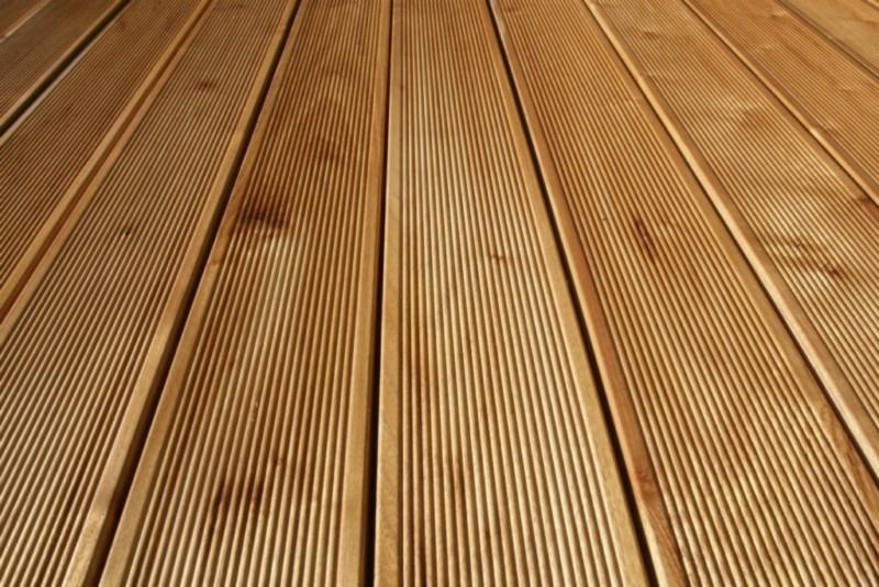 Ryflowana deska tarasowa z akacji, ułożona równolegle, widoczna pod kątem, z naturalnym usłojeniem drewna.