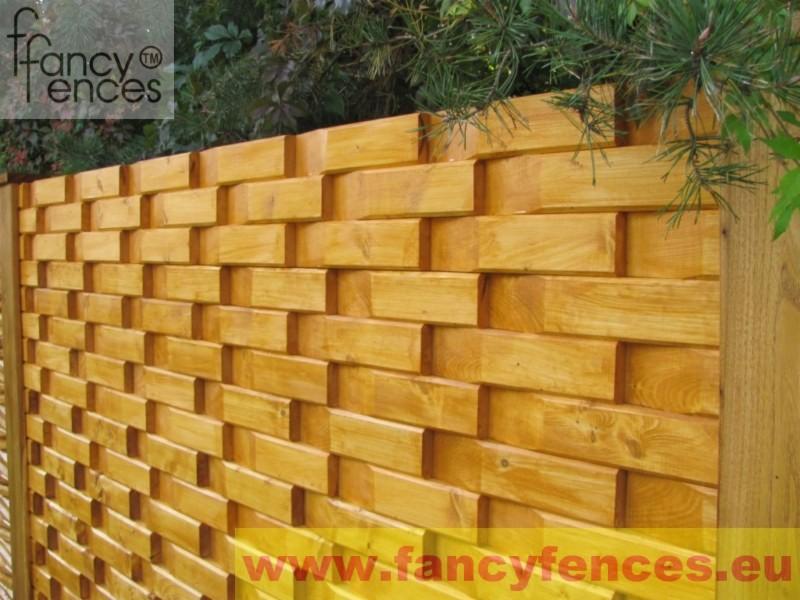 Patentowe ogrodzenie FANCY FENCES z drewna, ułożonego w dekoracyjny wzór koszykowy, widoczne logo firmy w lewym górnym rogu i adres strony internetowej w dolnej części zdjęcia.