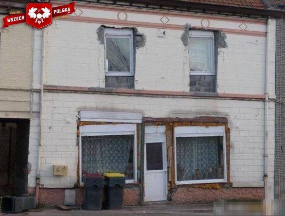 Fasada budynku z widocznymi śladami prac remontowych okien na piętrze oraz zniszczonymi nadprożami okien i drzwi na parterze.