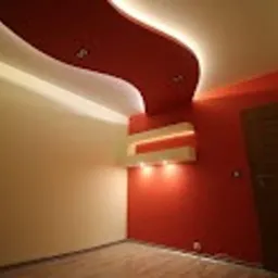 Pokój z pomalowaną na czerwono ścianą i sufitem z dekoracyjnym oświetleniem LED, widoczna pusta przestrzeń podłogi i drzwi po prawej stronie.