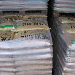 Stosy worków z opałem 'PIEKLORZ' 20kg, ułożone na paletach i owinięte folią stretch.