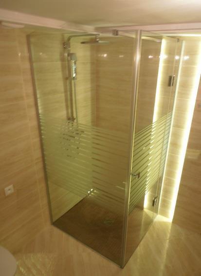 Szklana kabina prysznicowa z poziomymi pasami matowionego szkła, chromowana armatura, beżowe płytki na ścianach i podłodze, oświetlenie LED w rogu kabiny.