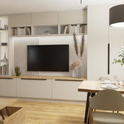 Aleksandra Bojakowska-Wszołek ALPRA - projektowanie wnętrz - Jasne wnętrze salonu z jadalnią, minimalistyczny design, drewniany stół z nakryciem, telewizor na ścianie z dekoracyjną zabudową, stolik kawowy z laptopem i filiżanką.