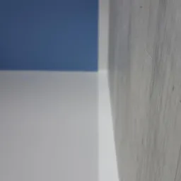 Fragment wykończonego wnętrza: ściana pomalowana na biało i niebiesko, z widoczną jasną podłogą panelową z delikatnym wzorem drewna, sfotografowaną pod kątem.