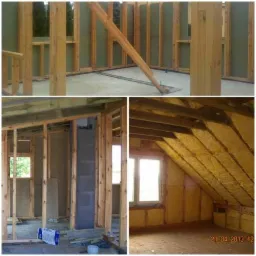 Wnętrze domu w trakcie budowy: widoczne drewniane ramy konstrukcyjne, izolacja ścian, okno w szczycie poddasza, fragment podłogi z datą 21.04.2013.