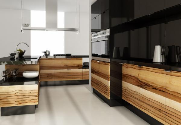 Nowoczesna kuchnia z drewnianymi frontami szafek o wyraźnym usłojeniu, czarnymi blatami i błyszczącymi, czarnymi szafkami wiszącymi, wyposażona w srebrny okap i armaturę.