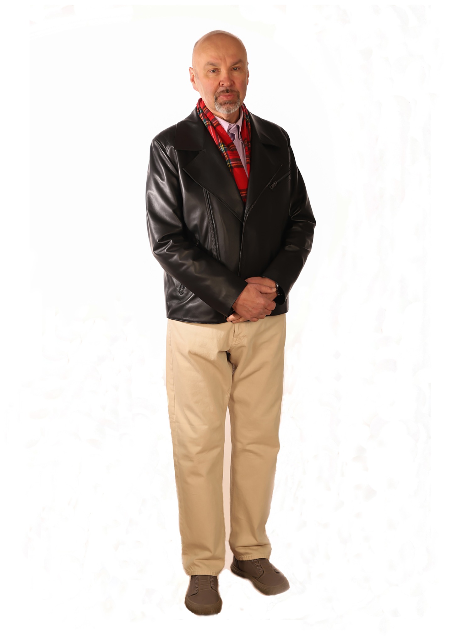 Portret mężczyzny w czarnej skórzanej kurtce, beżowych spodniach i czerwono-zielonym szaliku na białym tle.