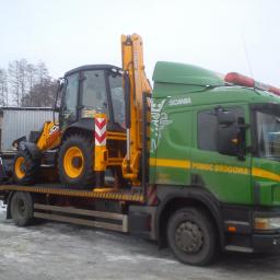 P.H.U. JANTRUCK s.c.Sebastian i Marcin Jankowiak - Zielona laweta Scania z żółtą koparko-ładowarką JCB na platformie. Widoczny napis 'Pomoc Drogowa' i sygnały świetlne. Zimowy krajobraz w tle.