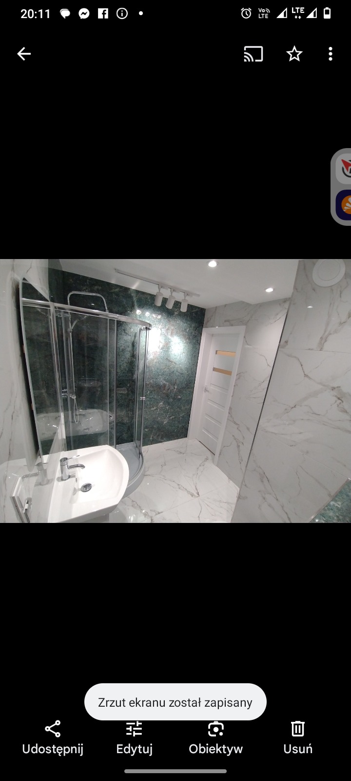 Nowoczesna łazienka z kabiną prysznicową, umywalką na postumencie i marmurowymi płytkami w odcieniach bieli i zieleni. Oświetlenie punktowe podkreśla elegancki wystrój.