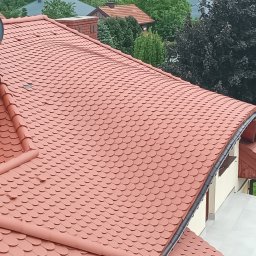 Usługi Wysokościowe FHU Mix Bud Piotr Smagacz - Dach pokryty czerwoną dachówką karpiówką, widok z góry, zarys komina i zieleni w tle.