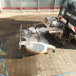 Usługi Wysokościowe FHU Mix Bud Piotr Smagacz - Maszyna CMAR LC580 z obrotowymi szczotkami czyszczącymi, widoczne efekty mycia kostki brukowej przed budynkiem drogerii-perfumerii.