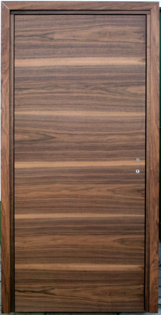 Drewniane drzwi z widocznym usłojeniem, dwa otwory na klamkę i zamek, prosty design.