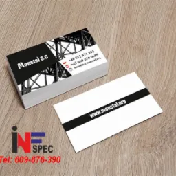 Stos wizytówek firmy Monstal s.c. z grafiką konstrukcji stalowej i danymi kontaktowymi na drewnianym tle. Projekt wizytówki z czarnym paskiem i adresem strony.