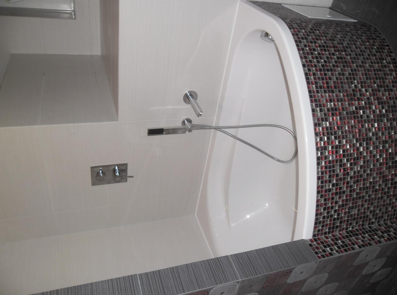 Wykończona mozaiką wanna w Bytomiu Odrzańskim. Bateria natryskowa zamontowana na białej, błyszczącej ścianie. Uwagę przykuwa nowoczesny design i dbałość o detale.