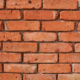 ATP SERVICE Paweł Motek - Fragment ściany z czerwonej cegły poniemieckiej, widoczne nierówności i porowata struktura, spoiny między cegłami wypełnione szarą zaprawą.