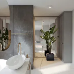 Elegancka łazienka z marmurowymi ścianami, owalną umywalką na blacie, złotą armaturą i dużym lustrem z dekoracyjną ramą, oświetlona neutralnym światłem, z roślinami w donicach.