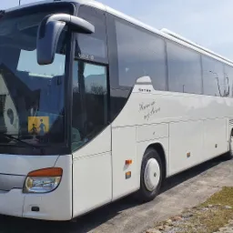 Biały autokar Setra S416 GT-HD z napisem 'Harmonie auf Reisen' na parkingu, widoczny znak ostrzegawczy dla dzieci.