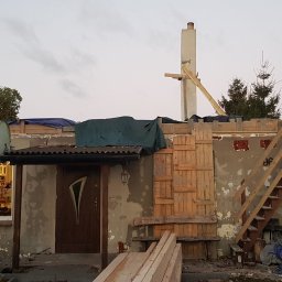 TWÓJ DACH Aleksander Mientki - Dom w trakcie remontu dachu z widoczną konstrukcją drewnianą, zabezpieczony plandeką, z częściowo zdjętym czerwonym pokryciem i odsłoniętą cegłą, z elementami rusztowania i schodami na zewnątrz.