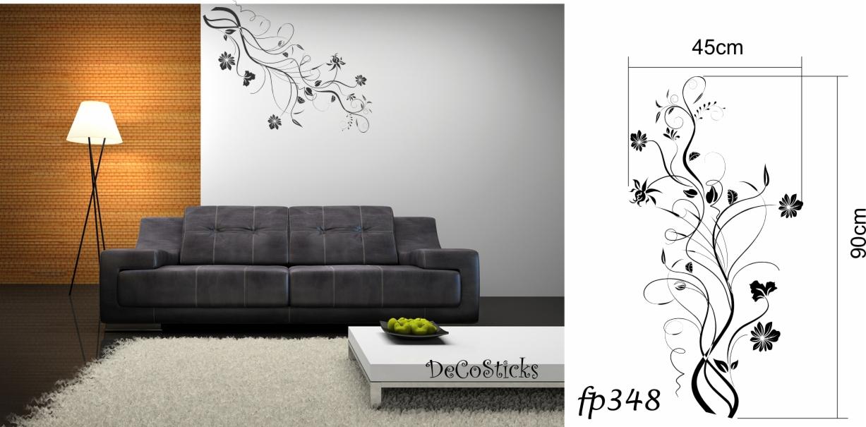 Aranżacja salonu z szarą kanapą, lampą stojącą i naklejkami dekoracyjnymi na ścianie w kształcie gałęzi z kwiatami, widok na ścianę z naklejkami i częściowo na schemat z wymiarami naklejki.